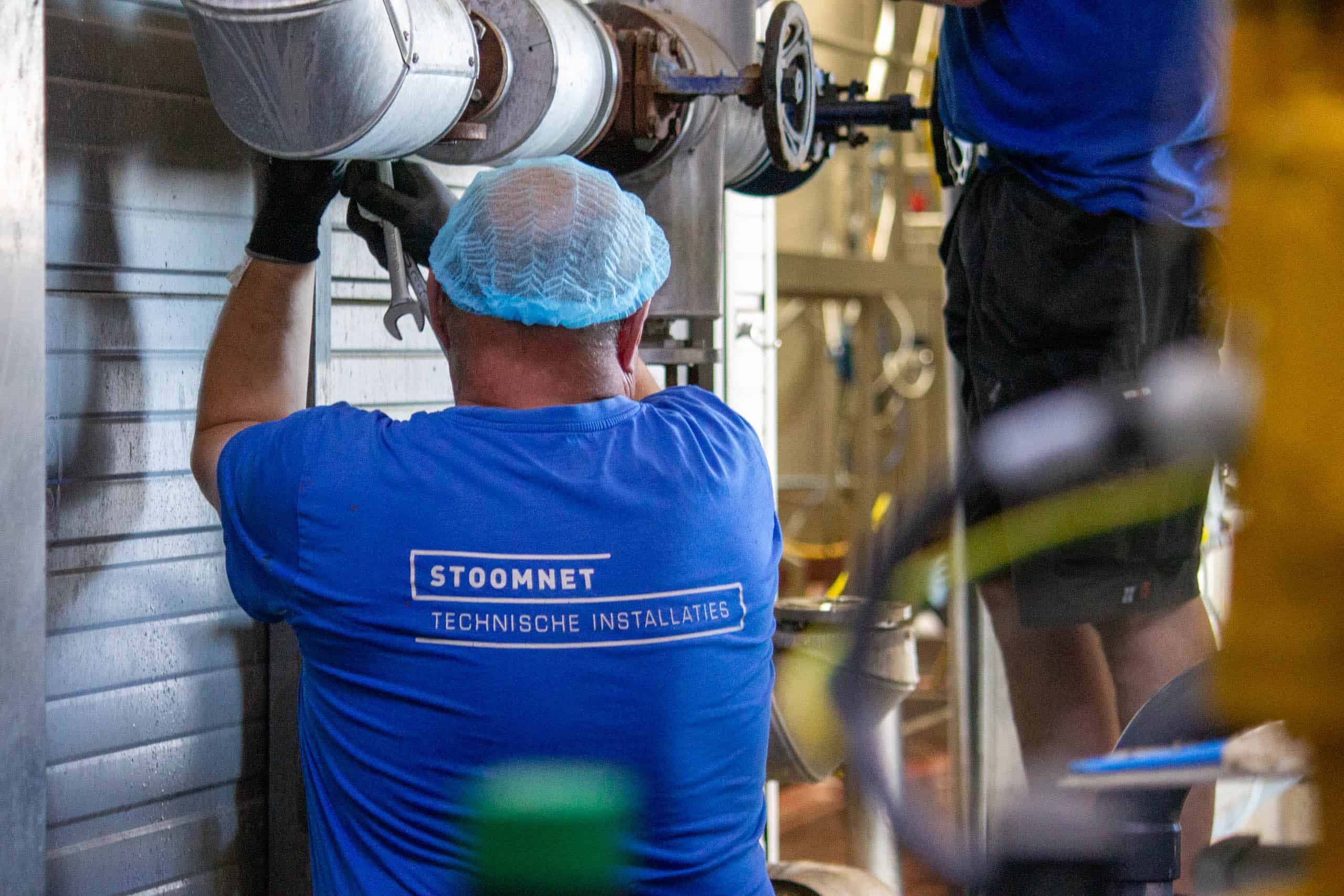 Stoomnet monteur aan het werk bij leidingwerkzaamheden in fabriek in voedselindustrie.