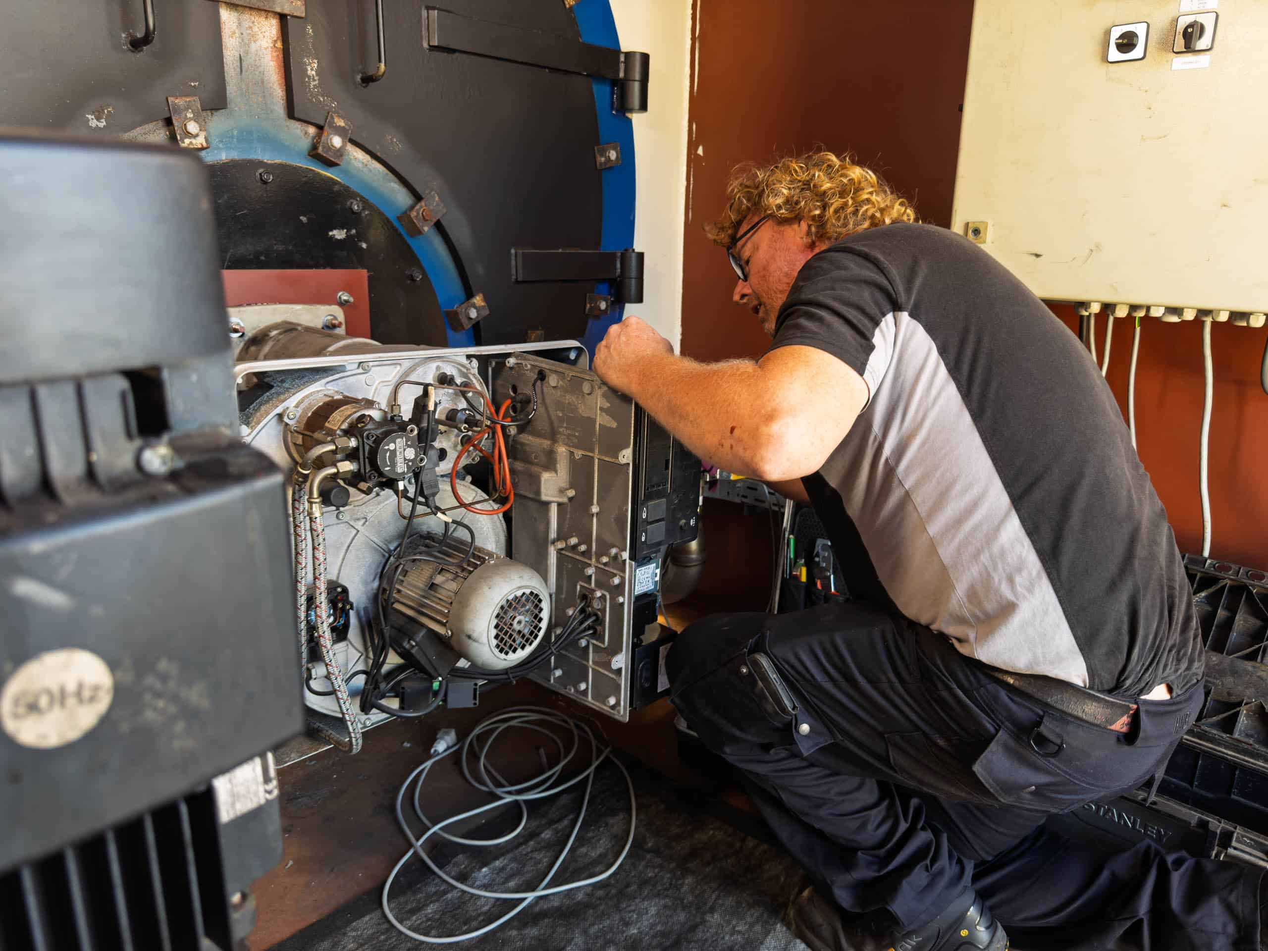 Stoomnet monteur aan het werk aan binnenzijde huurketel.